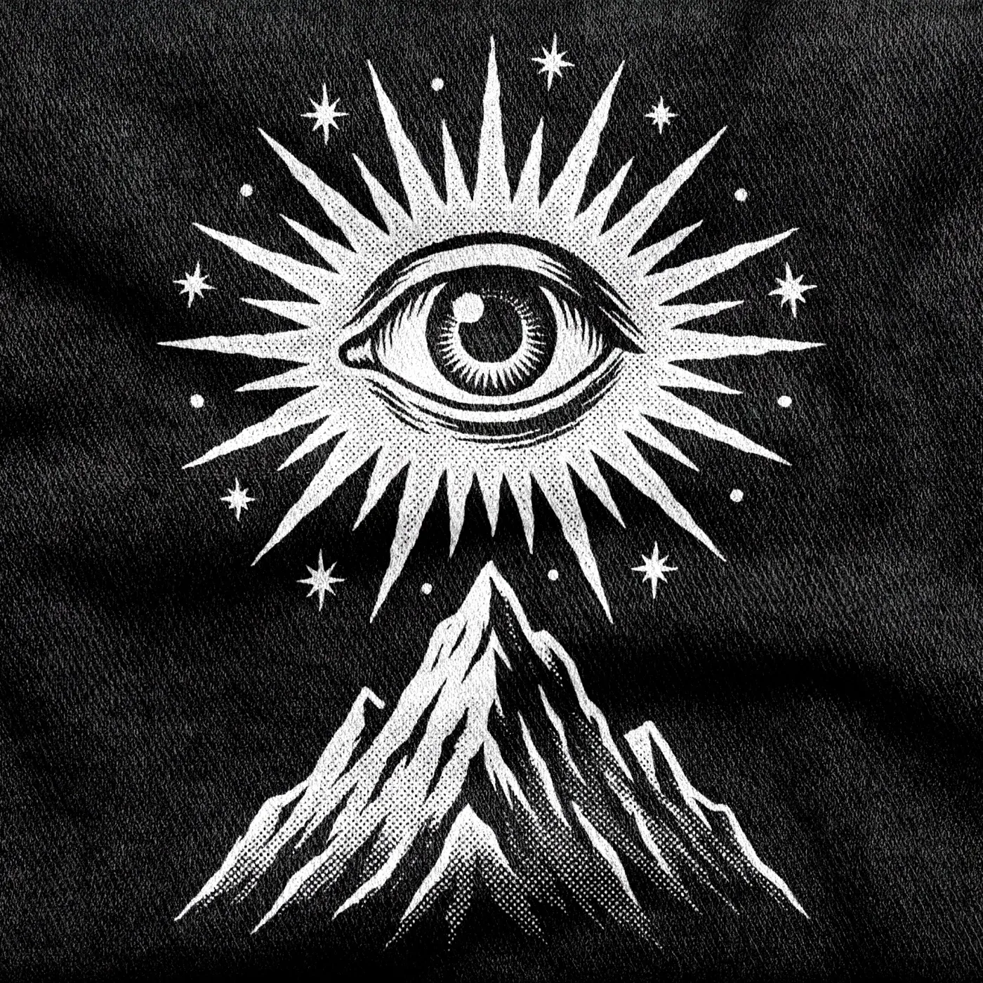 A giant cosmic all-seeing eye floating over a mountain peak, radiating rays and scattered stars, white on a black tee.