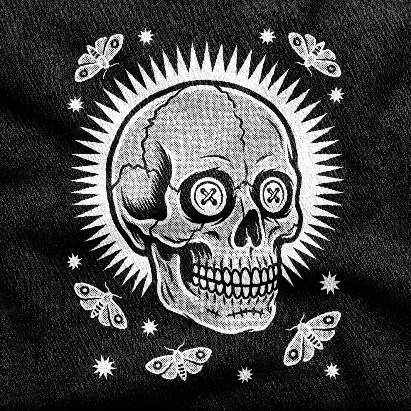 A skull with stitched button eyes ringed by death's-head moths, the Memento Vivere emblem, white on a black tee.
