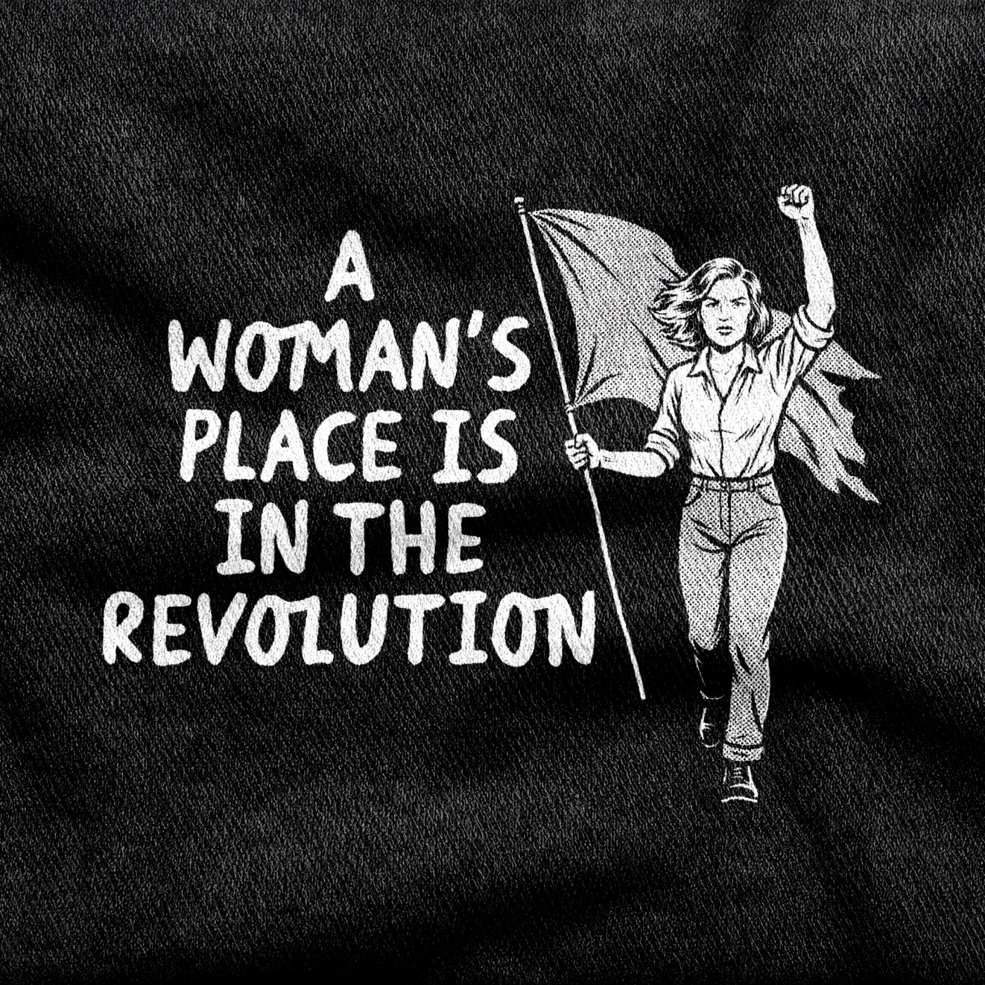 A woman walking forward with a raised fist and a flag, "A Woman's Place is in the Revolution", white on a black tee.