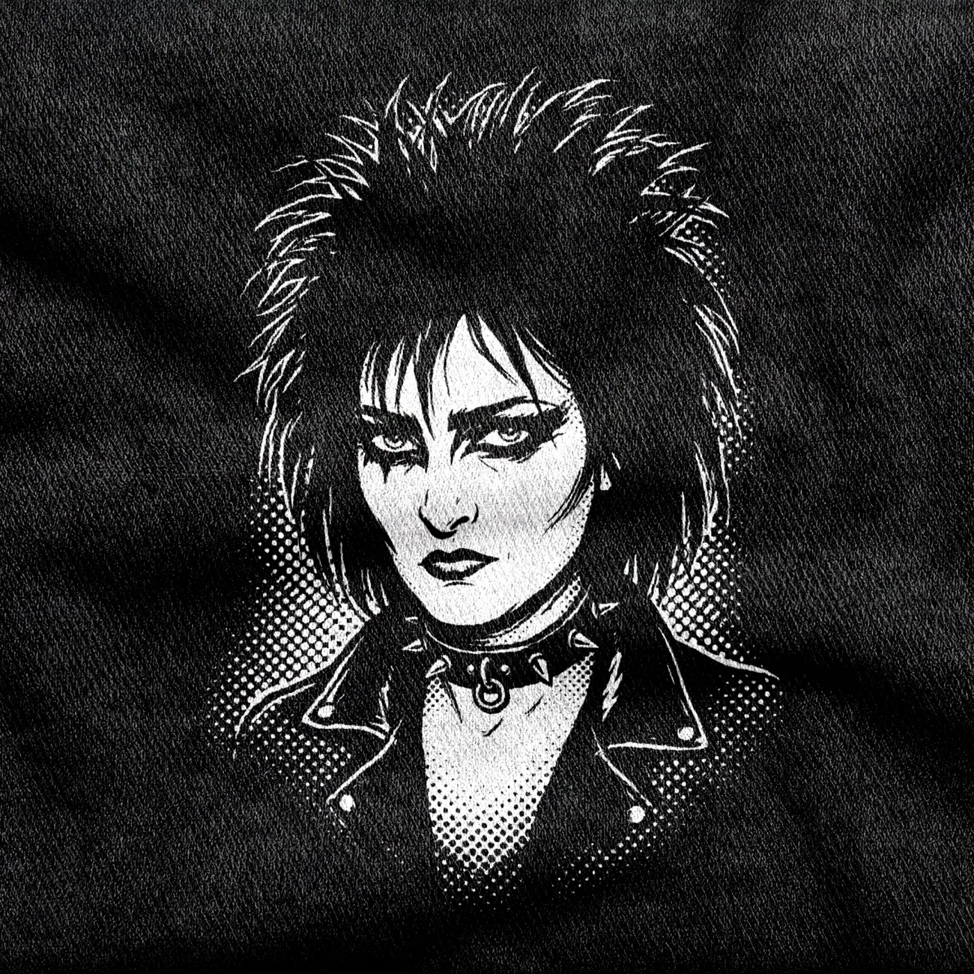 A portrait of post-punk singer Siouxsie Sioux with heavy kohl-black eyes, white on a black tee.