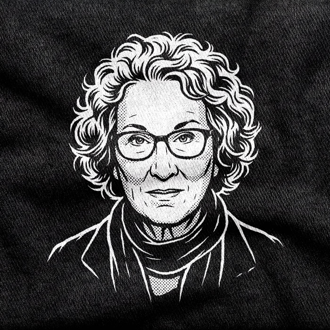 A portrait of the novelist Margaret Atwood under her halo of curls, glasses on, looking straight out, white on a black tee.