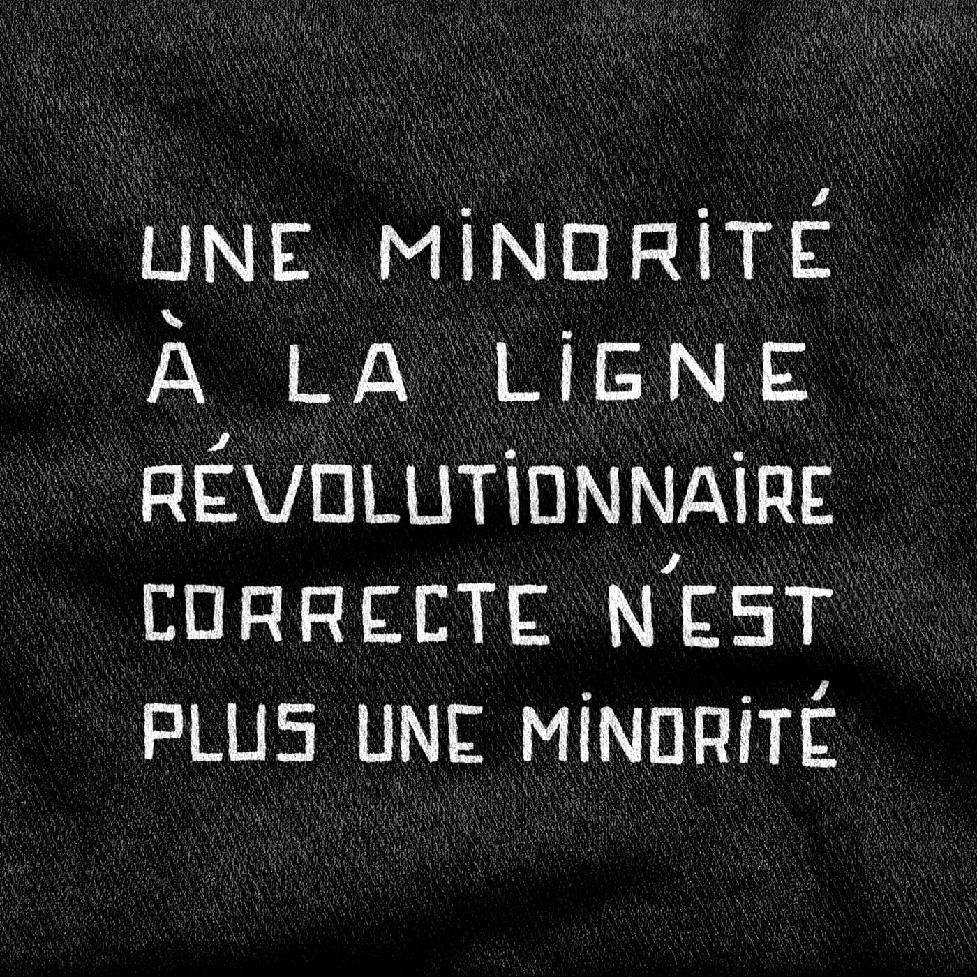 Stencil capitals reading "Une minorité à la ligne révolutionnaire correcte n'est plus une minorité", five lines deep, white on a black tee.