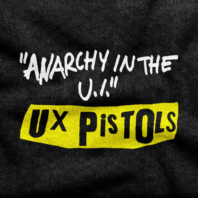 Punk handwritten text reading "Anarchy in the U.I." above a ransom-note yellow bar lettered "UX Pistols", white and yellow on a black tee.