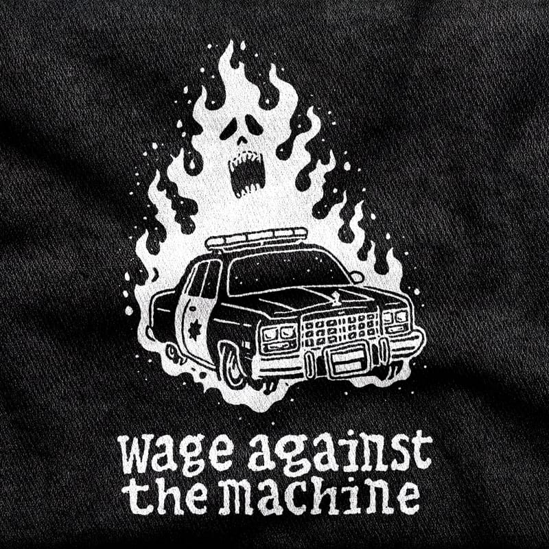 A burning police cruiser with the flames rising into a screaming skull, under lowercase hand-drawn type, white on a black tee.