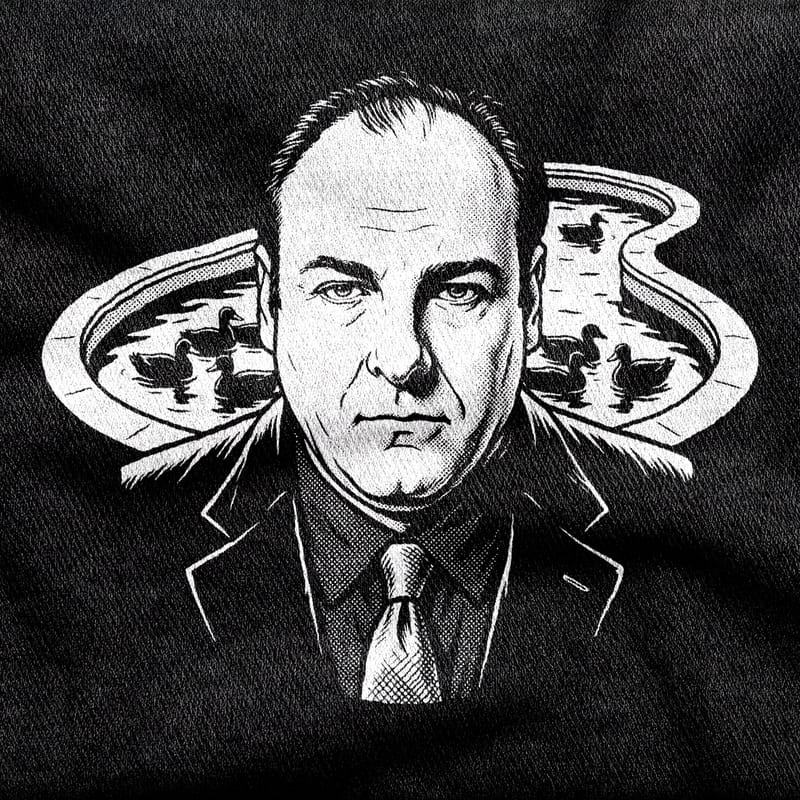 Tony Soprano in suit and tie staring dead ahead, flanked by the pool and its ducks, white on a black tee.