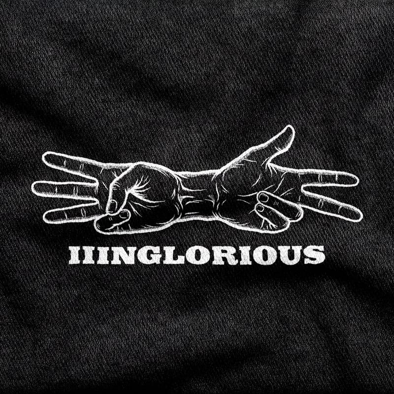 Two crossed hands showing the two ways of counting to three, over the Inglorious Basterds wordmark, white on a black tee.
