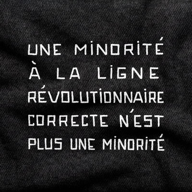 Stencil capitals reading "Une minorité à la ligne révolutionnaire correcte n'est plus une minorité", five lines deep, white on a black tee.